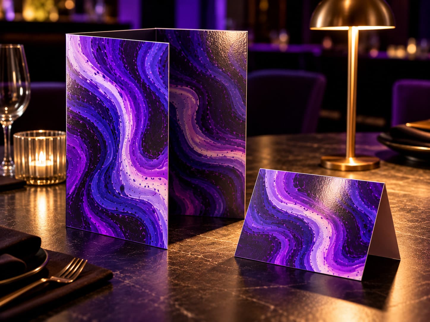 A laminated bi-fold menu standing beside a tent card on a dark restaurant table under a warm lamp
