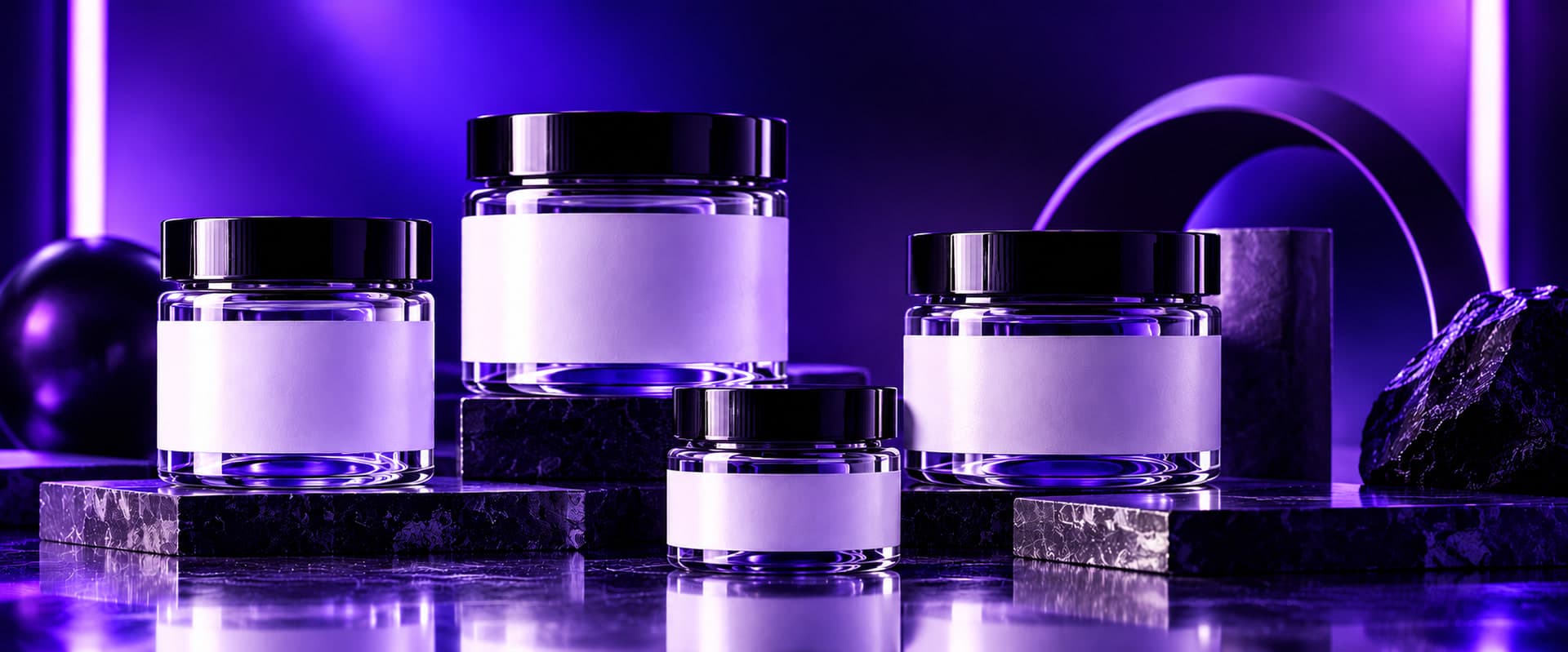 Four purple glass jars in ascending sizes, each with a blank white label