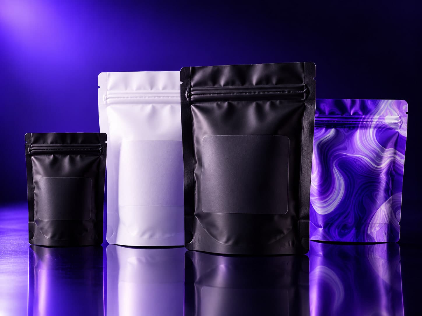 Four stand-up pouches in black, white, and a violet marble print